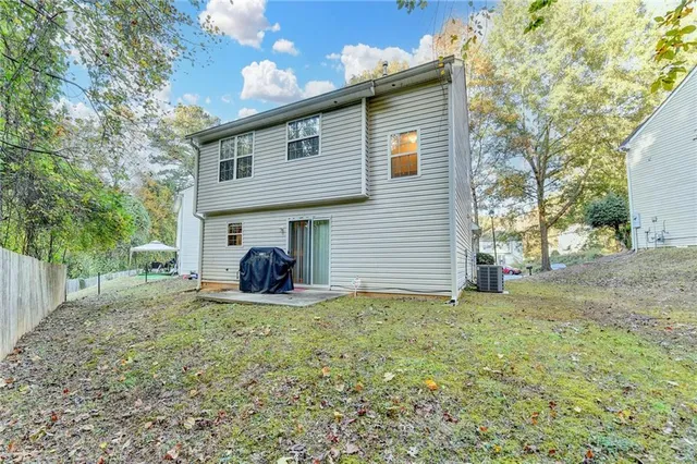 a view of a house with backyard and trees
