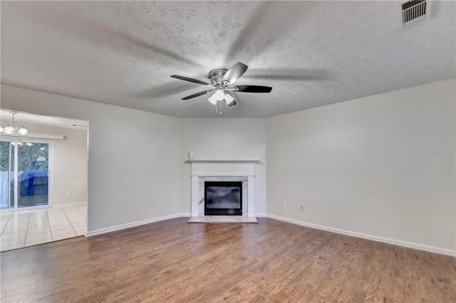 a view of an empty room with a fireplace and a window
