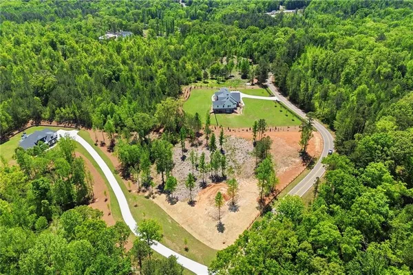 an aerial view of a house with a yard and swimming pool