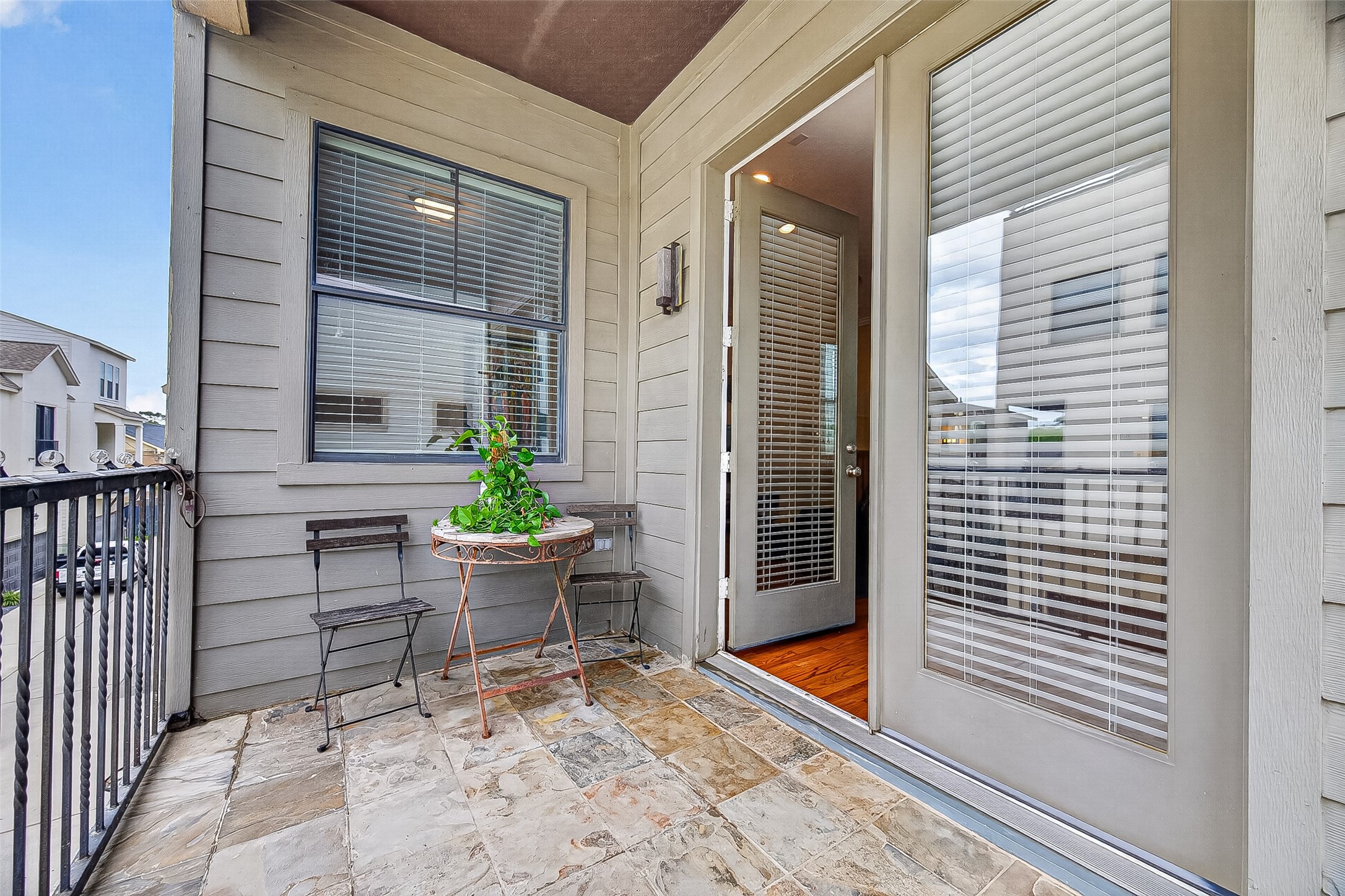 2611 Riverside Drive, Unit C Houston, TX 77004 - Photo 3 of 50 Charming balcony with stone tile flooring, ideal for relaxation and reading a book. With easy access to the living room and kitchen. Access through French doors with blinds, providing a cozy outdoor space.