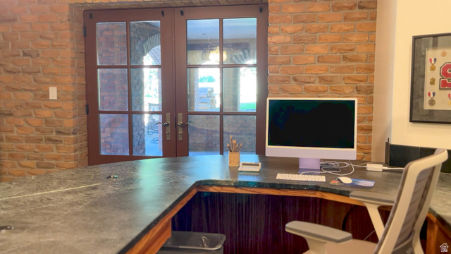 426 West Center Street Parowan, UT 84761 - Photo 59 of 107 Built-in desk featuring a stone-finish countertop, wood-finish base, and exposed brick wall