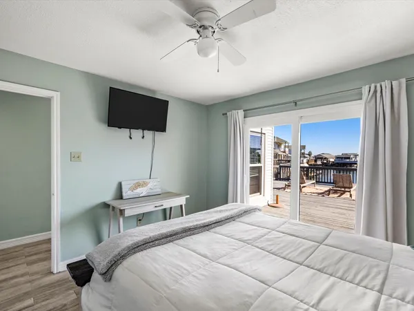 a bedroom with a bed a flat screen tv and a chandelier