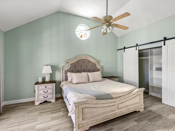 a bedroom with a bed and a ceiling fan