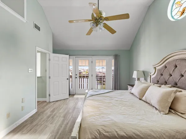 a bedroom with a balcony a bed and a chandelier