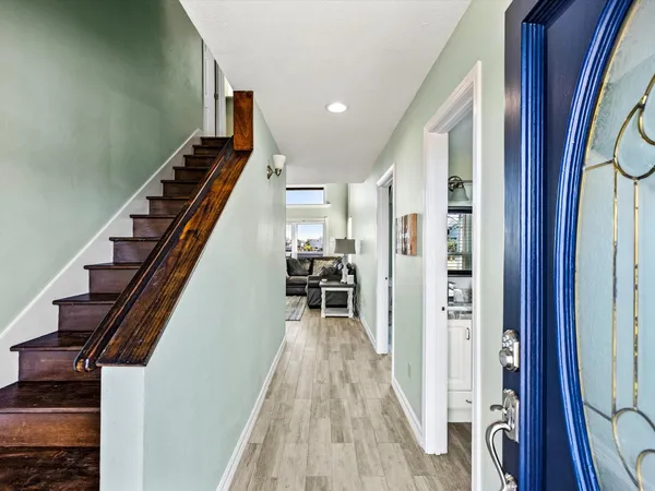 a view of a hallway with wooden floor and staircase