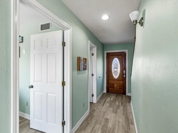 a view of a hallway with wooden floor