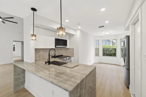 a kitchen with kitchen island a sink stainless steel appliances and window