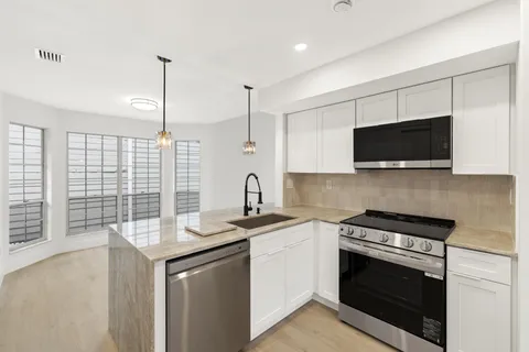 a kitchen with a sink stove and microwave