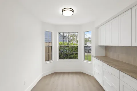a view of a kitchen with wooden floor and a window