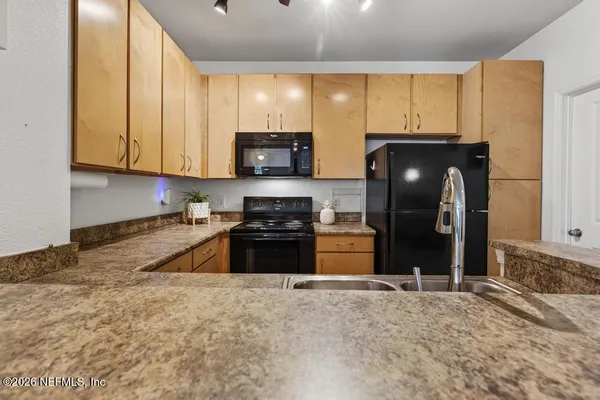 a kitchen with stainless steel appliances granite countertop a sink stove and cabinets