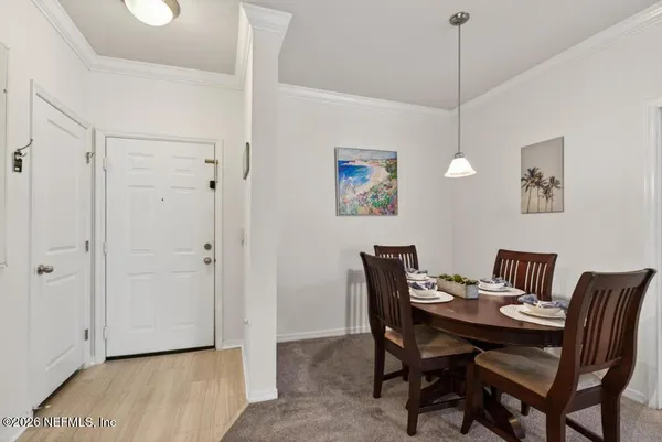 a view of a dining room with furniture a chandelier and wooden floor