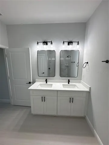 a spacious bathroom with a double vanity sink and mirror