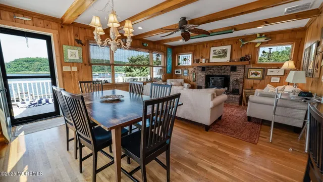 a dining room with furniture a fireplace and wooden floor
