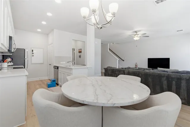 a living room with furniture a flat screen tv and a chandelier