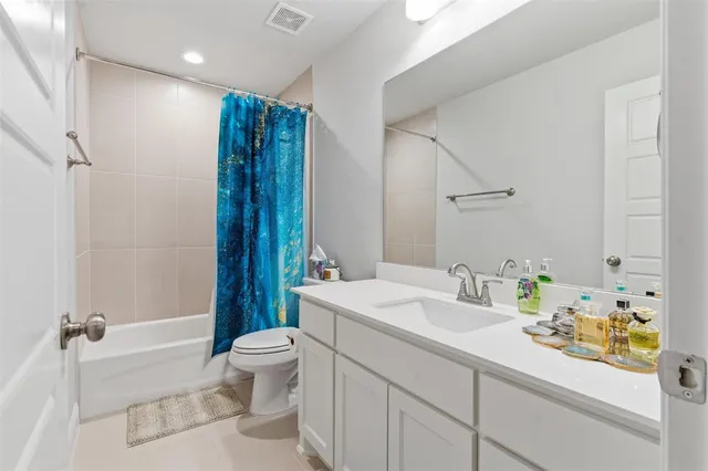 a bathroom with a sink a toilet and a large mirror