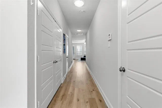 a view of a hallway with wooden floor and staircase