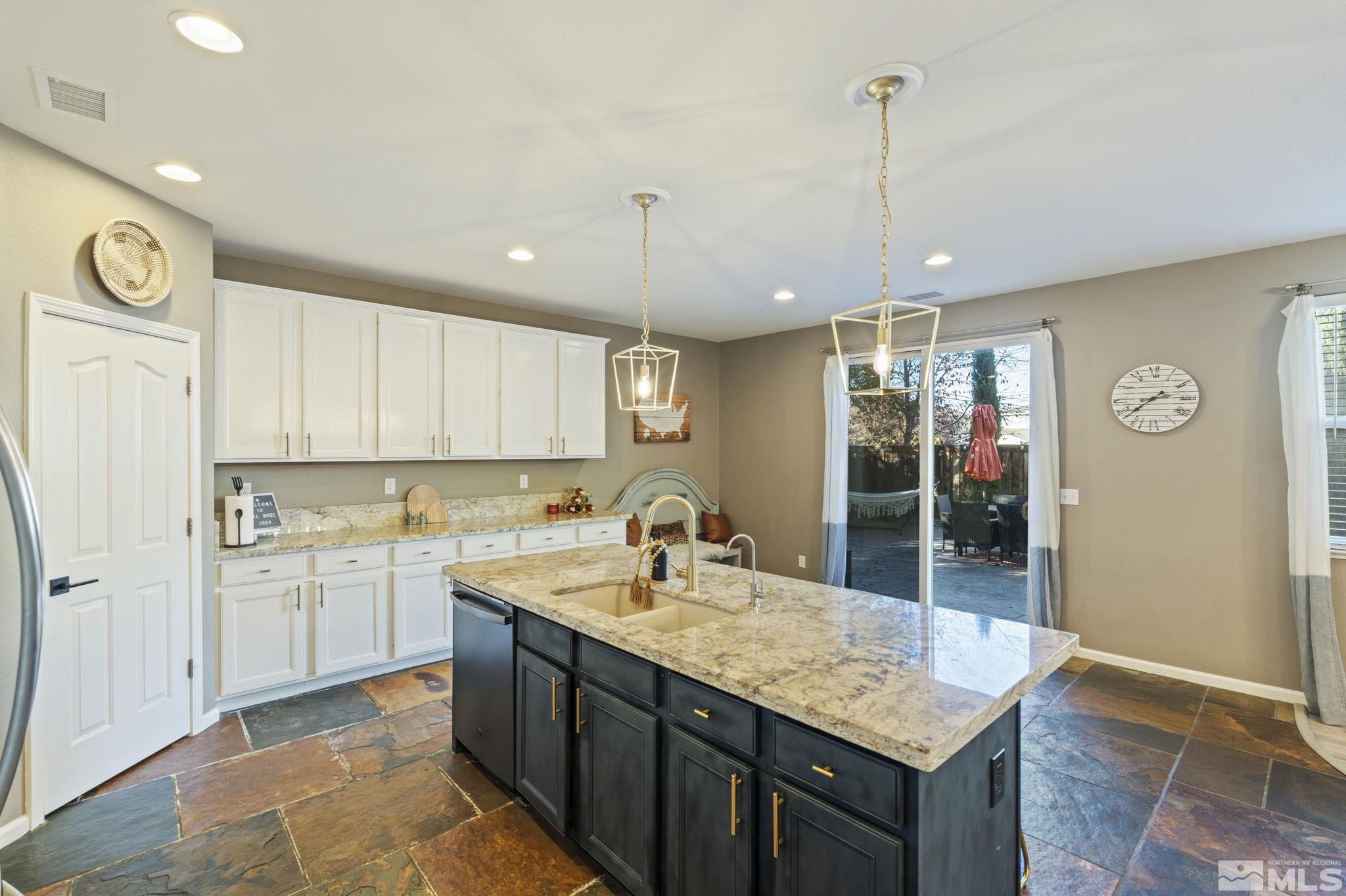 405 Teramo Court Reno, NV 89521 - Photo 11 of 40 a kitchen with center island and stainless steel appliances
