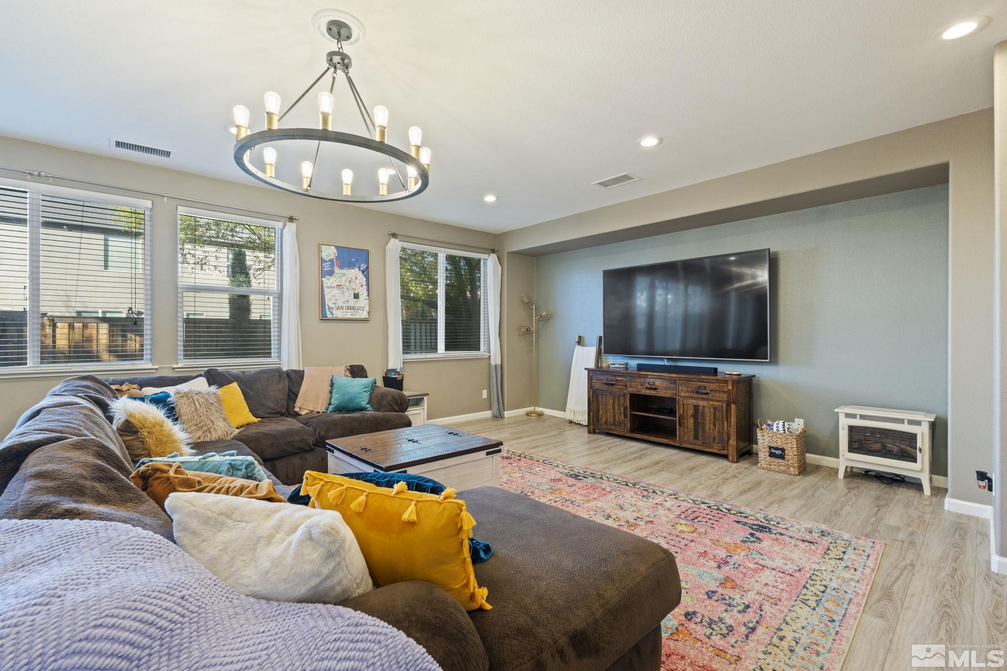 405 Teramo Court Reno, NV 89521 - Photo 14 of 40 a living room with furniture a flat screen tv and wooden floor