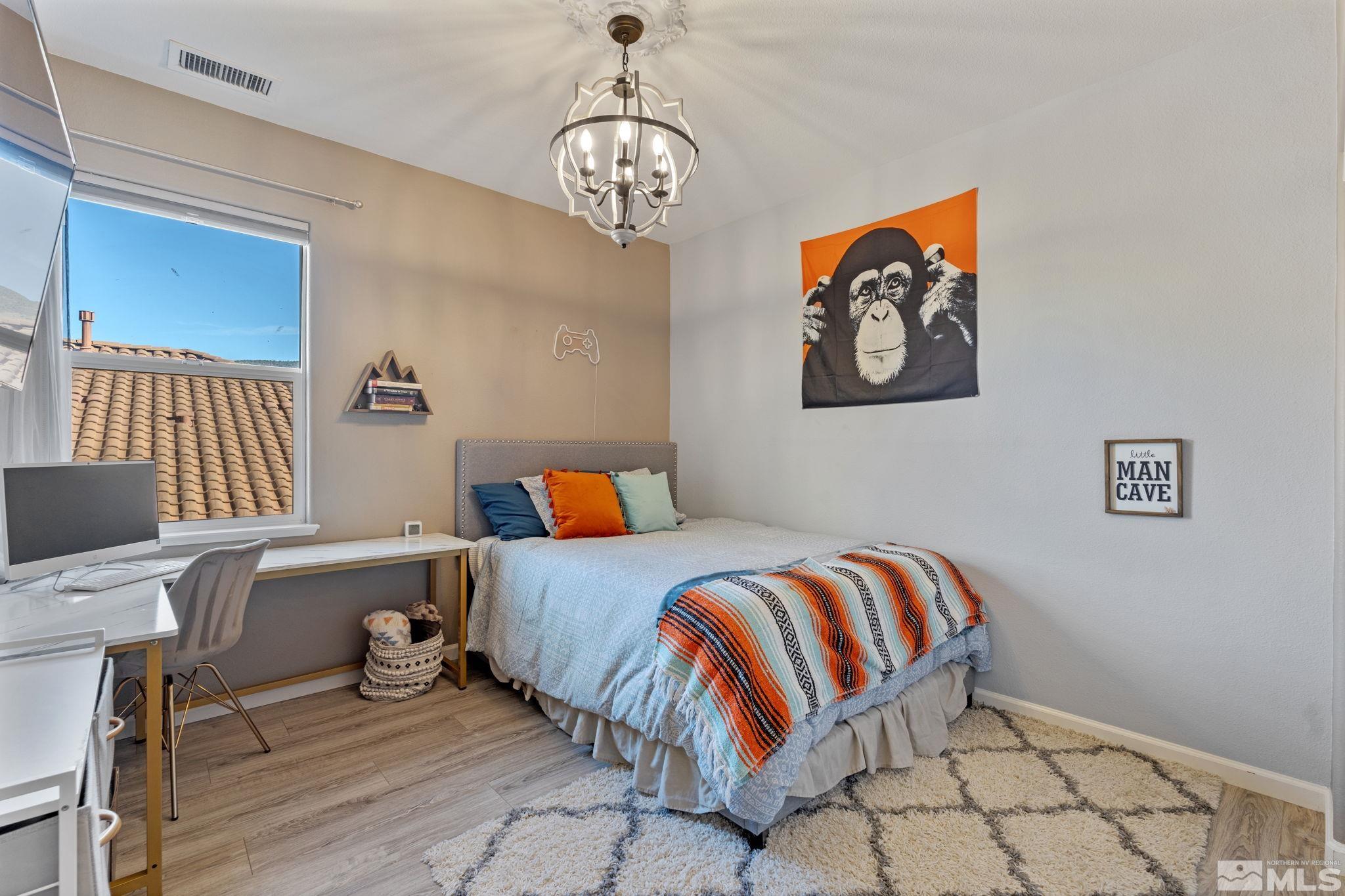405 Teramo Court Reno, NV 89521 - Photo 25 of 40 a bedroom with a bed and a chandelier