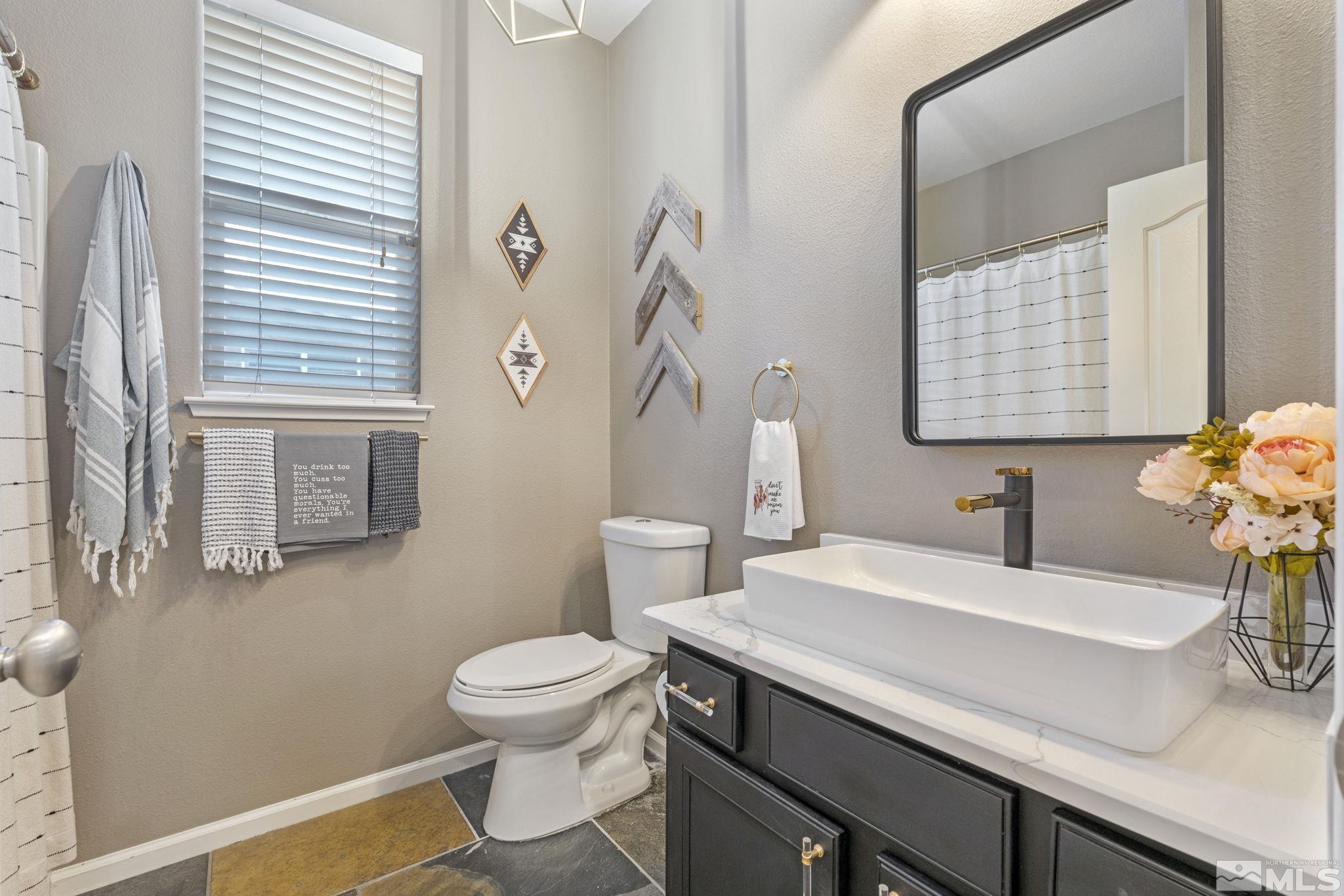 405 Teramo Court Reno, NV 89521 - Photo 29 of 40 a bathroom with a sink a toilet and mirror