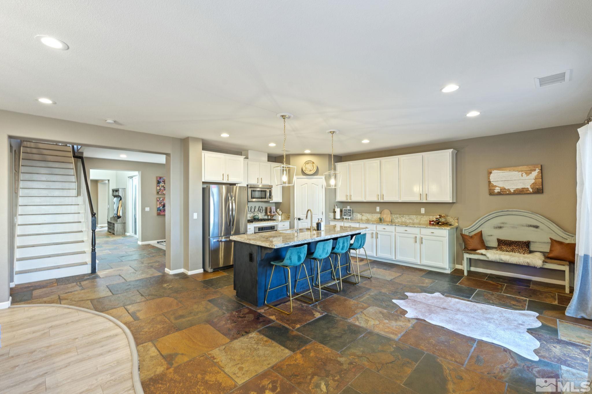 405 Teramo Court Reno, NV 89521 - Photo 5 of 40 a large white kitchen with kitchen island granite countertop a large window and a sink