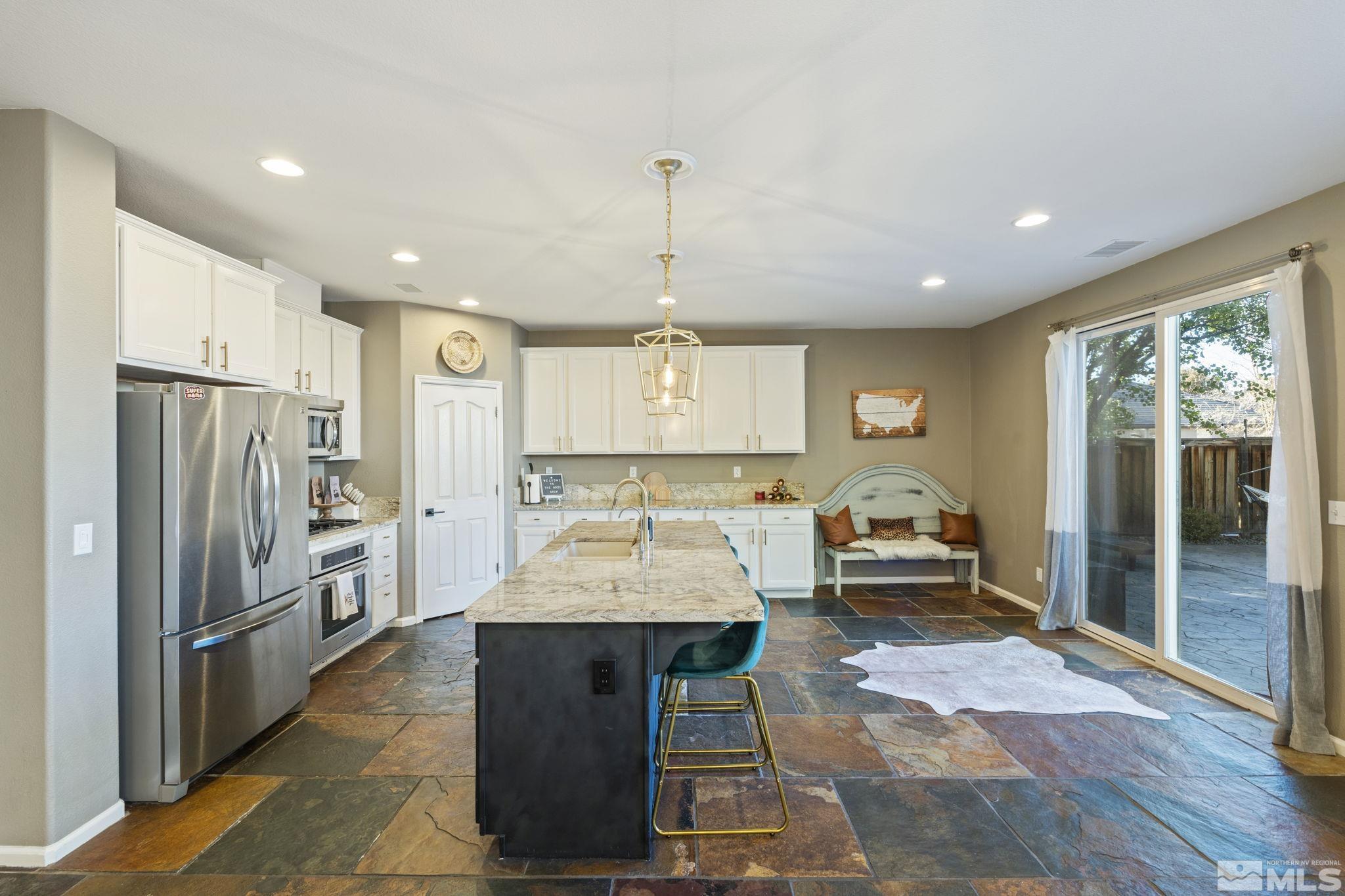 405 Teramo Court Reno, NV 89521 - Photo 6 of 40 a large kitchen with a center island wooden floor and stainless steel appliances