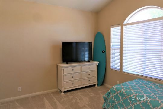 421 Mavis Court Ridgecrest, CA 93555 - Photo 24 of 33 a bedroom with a bed and a flat tv screen on dresser