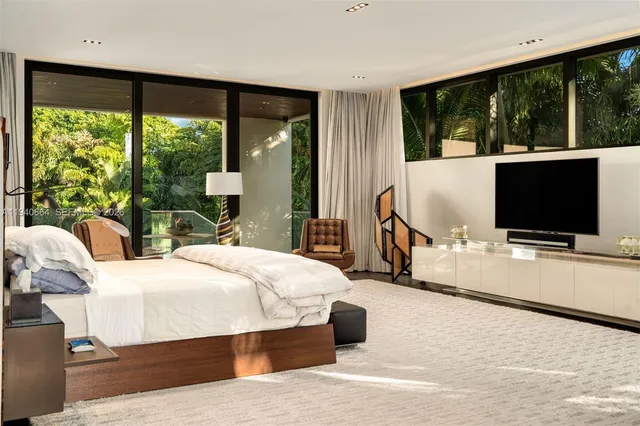 a bedroom with a bed and large windows