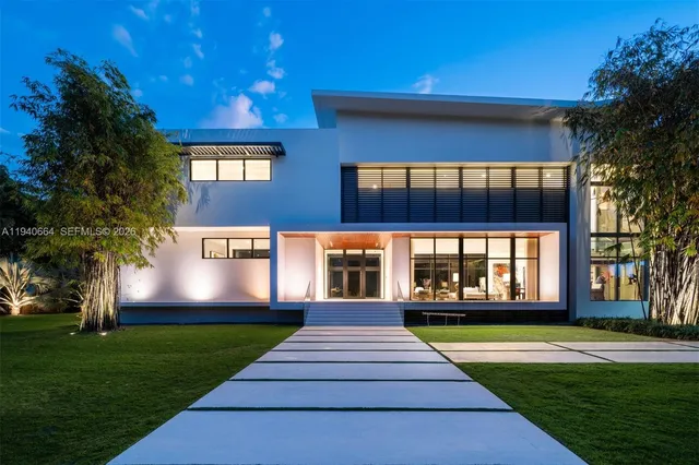 a view of a yard with plants and large trees