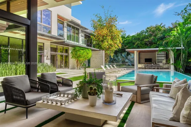 a view of a patio with couches table and chairs potted plants with wooden floor and fence