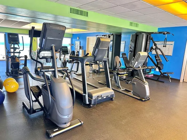 a living room with furniture a window and gym equipment