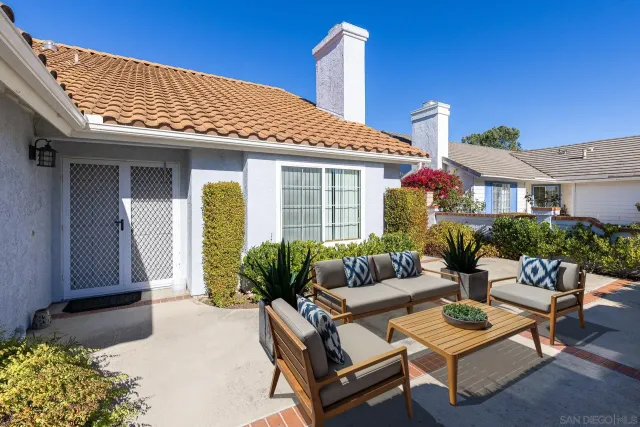 a view of a patio with couches table and chairs and potted plants