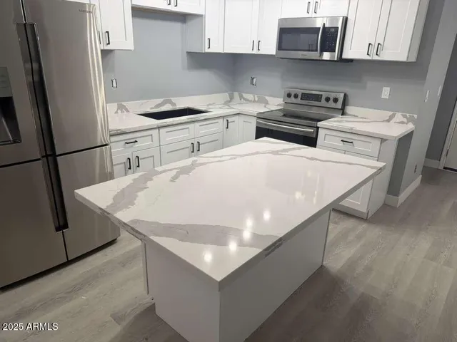 a kitchen with stainless steel appliances a stove a sink and a refrigerator