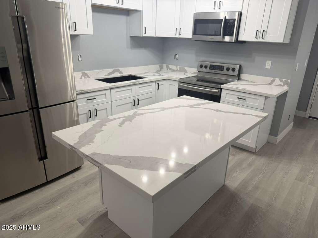 3619 West Griswold Road Phoenix, AZ 85051 - Photo 13 of 36 a kitchen with stainless steel appliances a stove a sink and a refrigerator