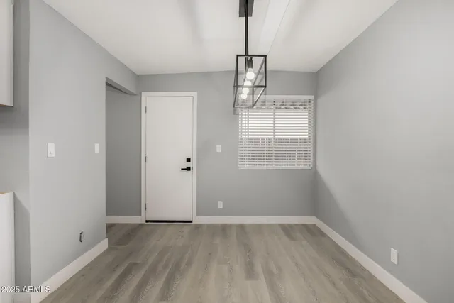 a view of empty room with wooden floor and window