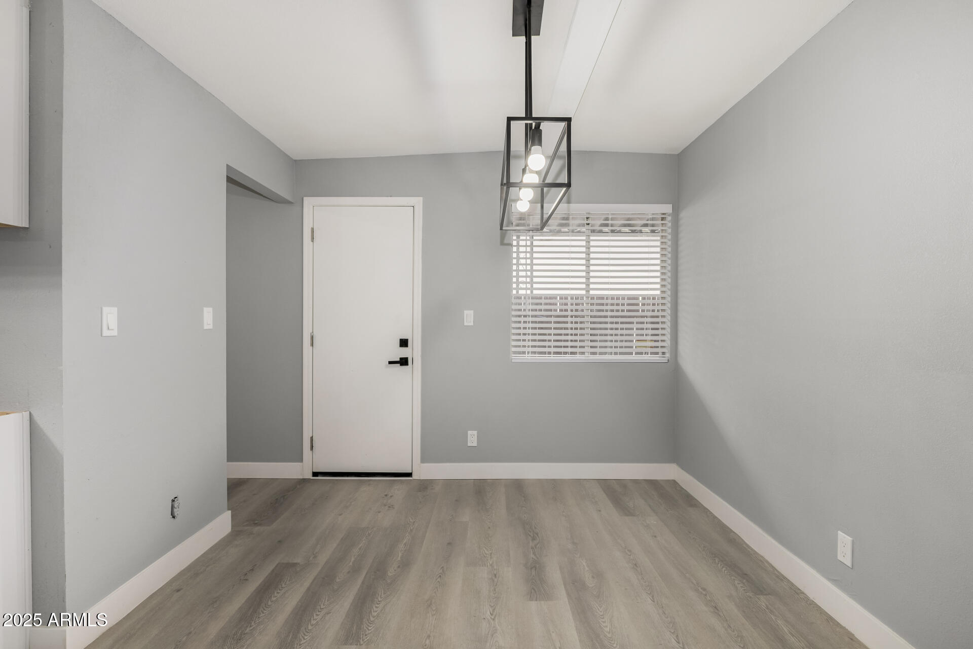 3619 West Griswold Road Phoenix, AZ 85051 - Photo 15 of 36 a view of empty room with wooden floor and window