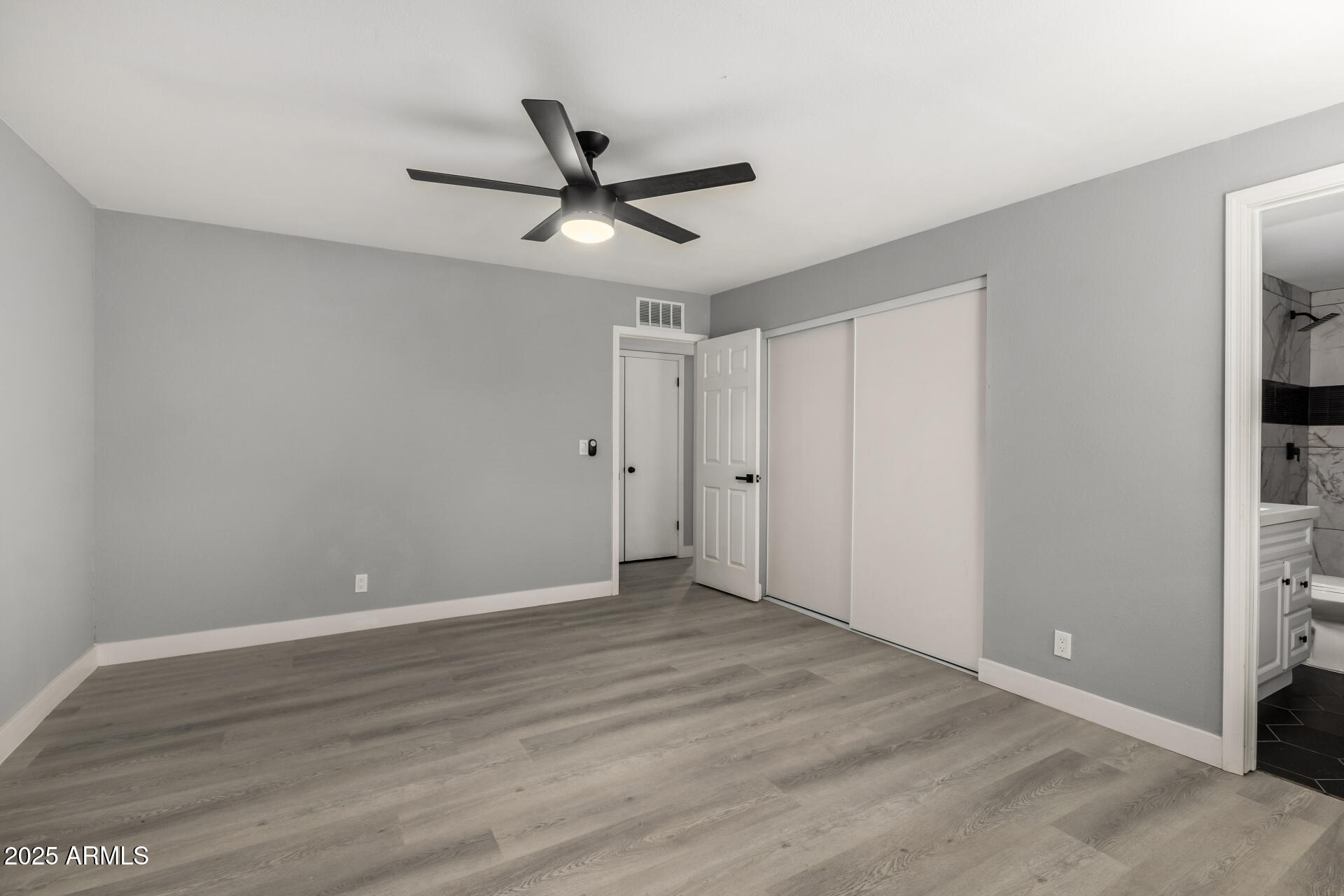 3619 West Griswold Road Phoenix, AZ 85051 - Photo 18 of 36 a view of a big room with wooden floor closet and windows in a room