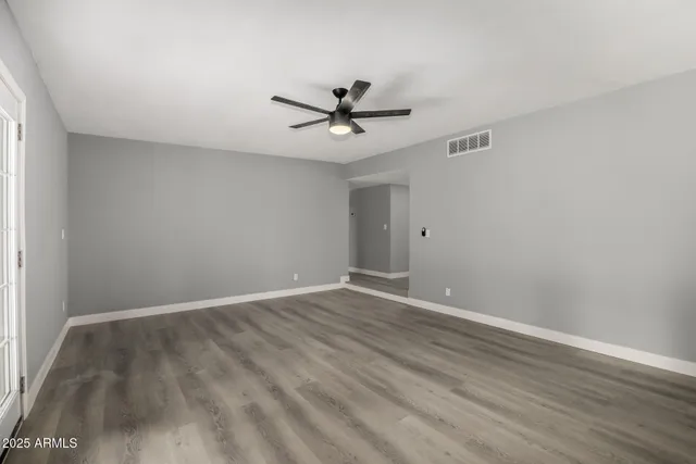 a view of a room with wooden floor and a ceiling fan