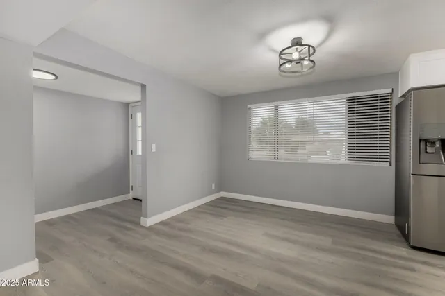 a view of empty room with wooden floor and window