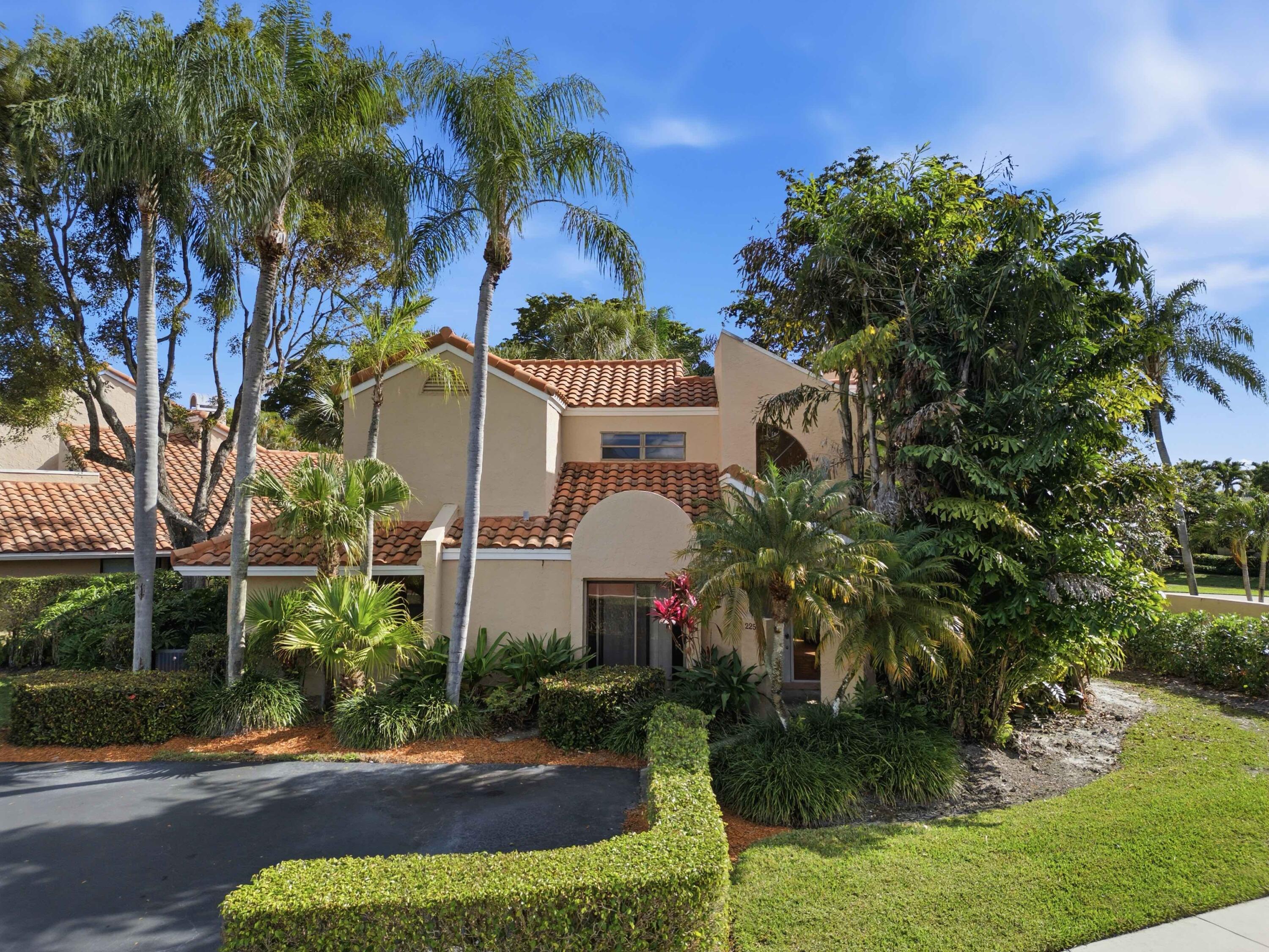 22511 Meridiana Drive Boca Raton, FL 33433 - Photo 12 of 40 a front view of a house with a yard and potted plants