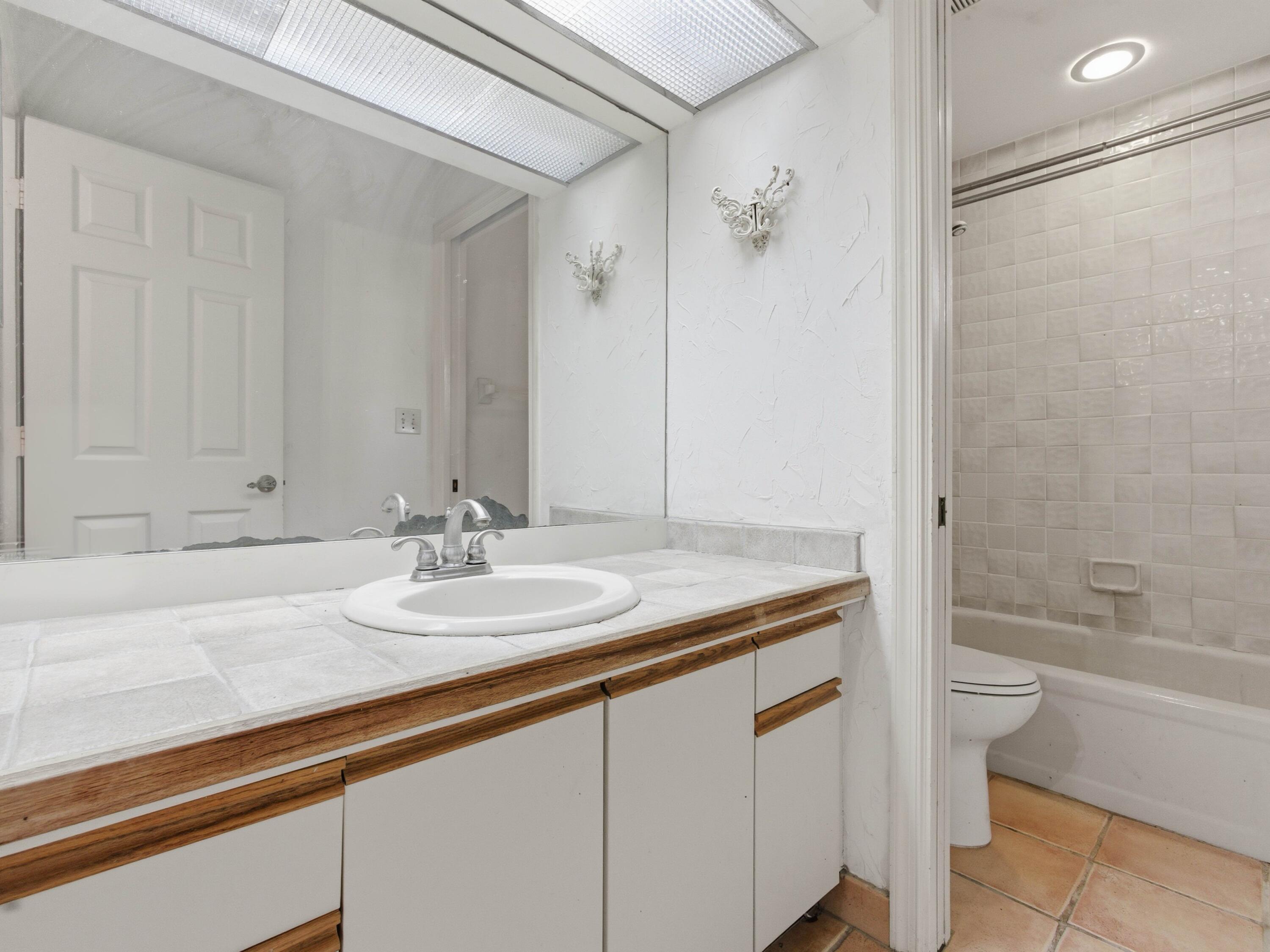 22511 Meridiana Drive Boca Raton, FL 33433 - Photo 13 of 40 a bathroom with a granite countertop sink a toilet and bathtub