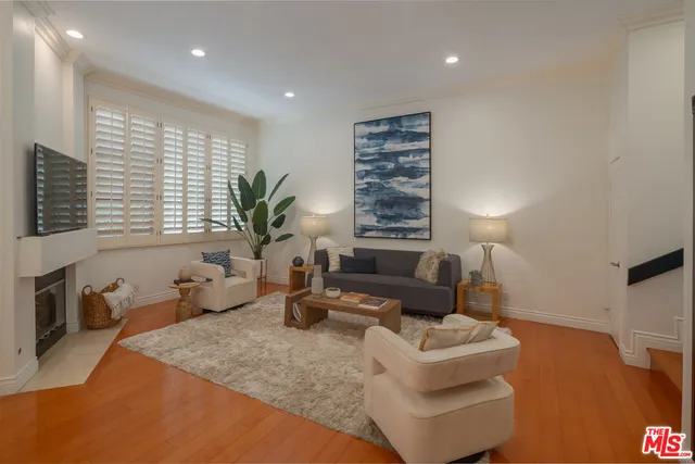 a living room with furniture a large window and potted plants