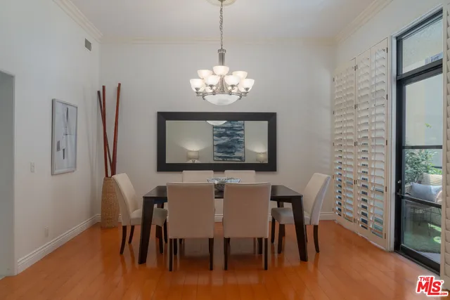 a dining room with furniture a chandelier and wooden floor