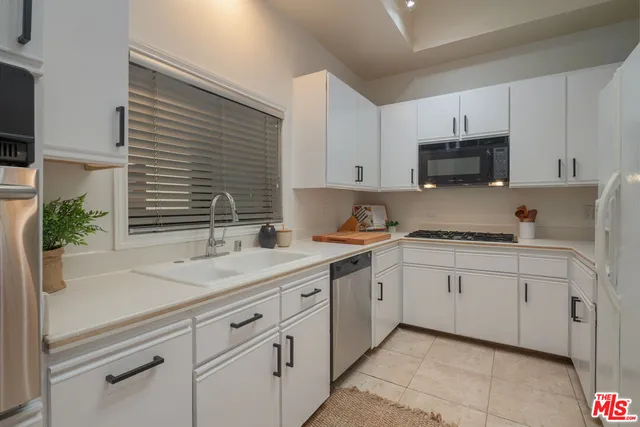 a kitchen with granite countertop white cabinets and white appliances
