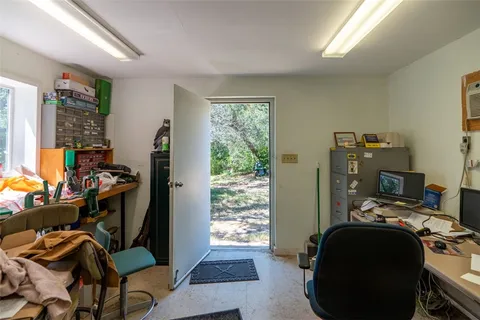 a view of a workspace with furniture and a window