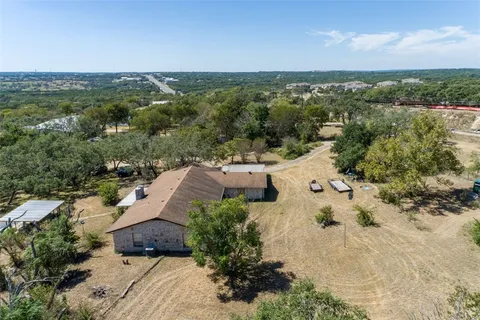 an aerial view of residential houses with outdoor space and trees