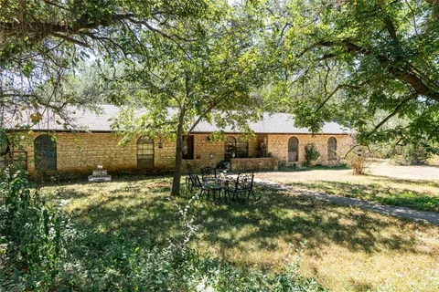 a backyard of a house with table and chairs