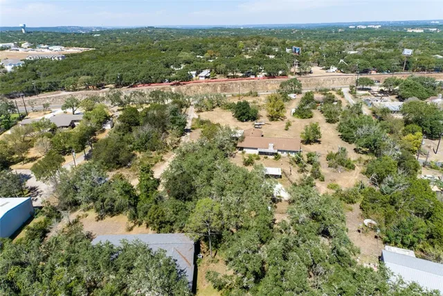 an aerial view of residential houses with outdoor space and trees