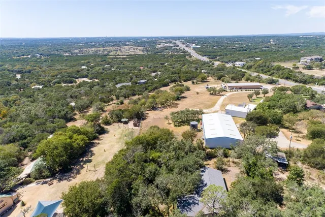 an aerial view of residential houses with outdoor space and trees