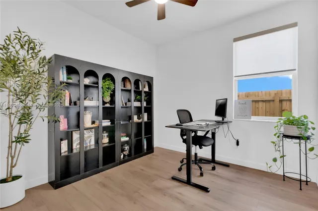 a view of a workspace with furniture and a window